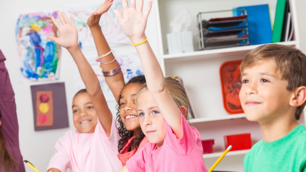 multiple people with their hands up to ask questions